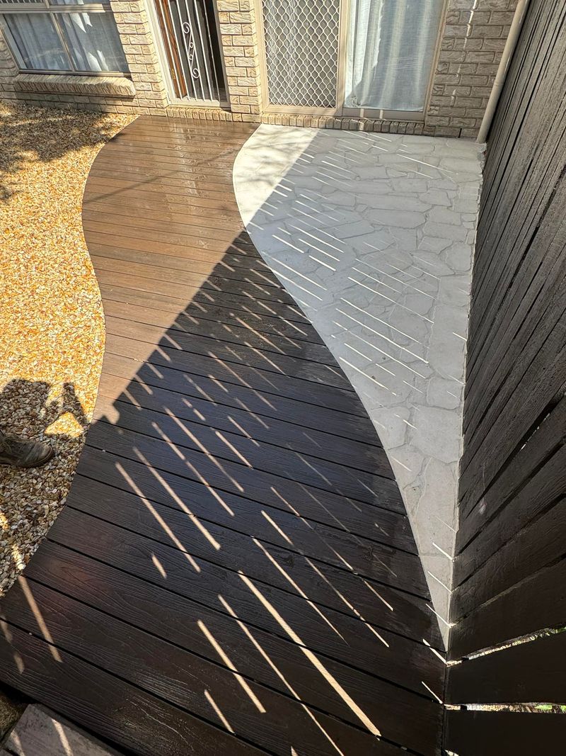 Curved timber decking with stone paving by BGL Services